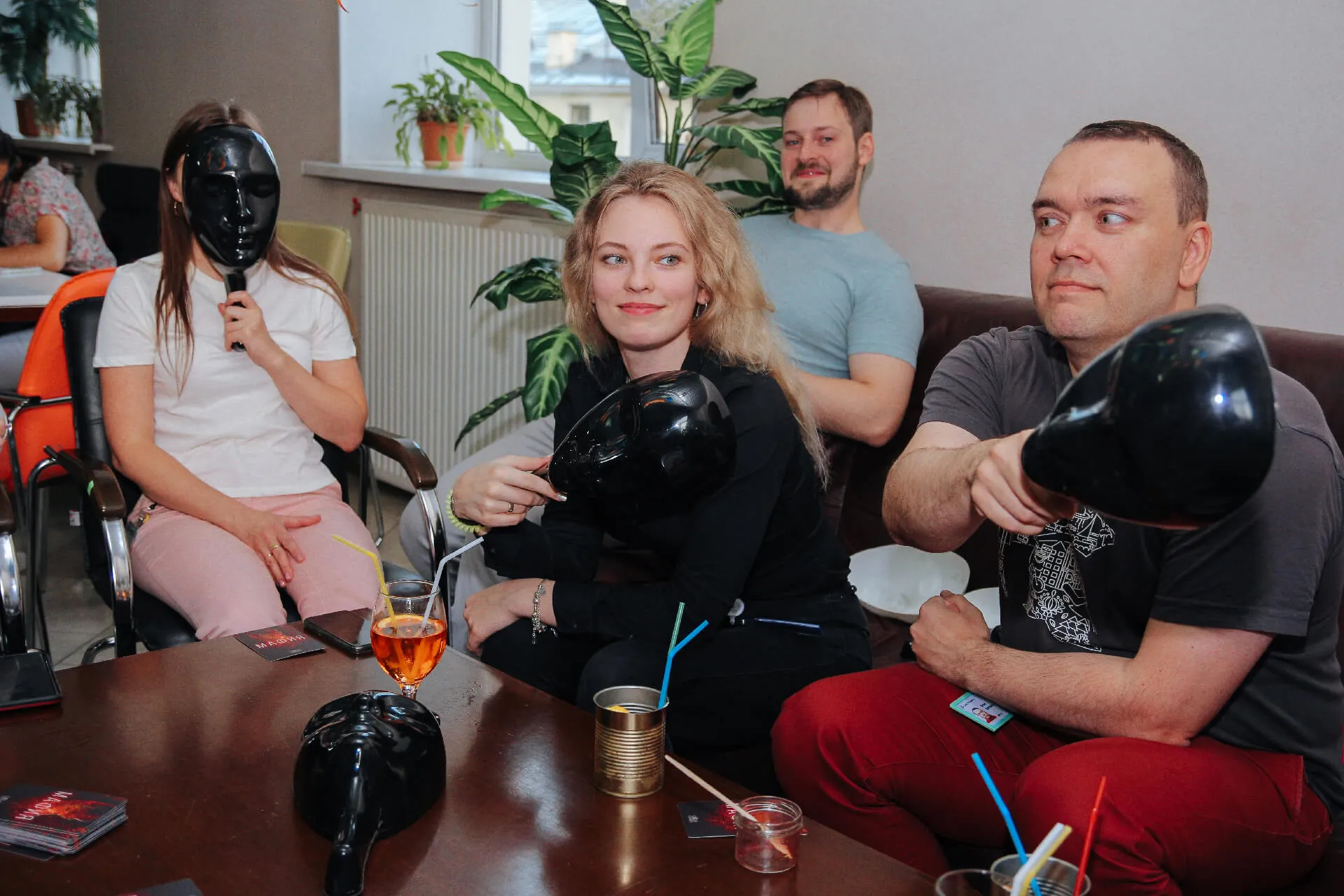 Group of people sitting and holding black masks during a gathering