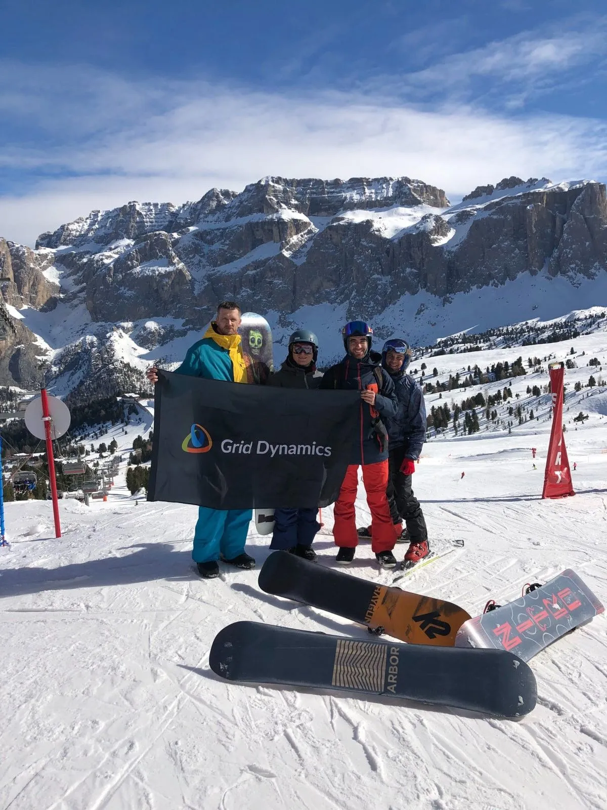People holding Grid Dynamics flag on a ski track