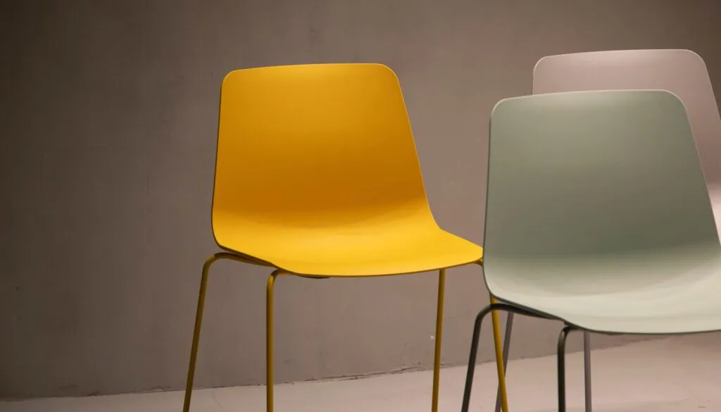 three chairs in pink, green, and yellow colors